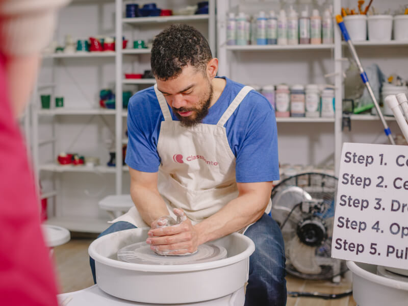 Man working with clay on a pottery wheel